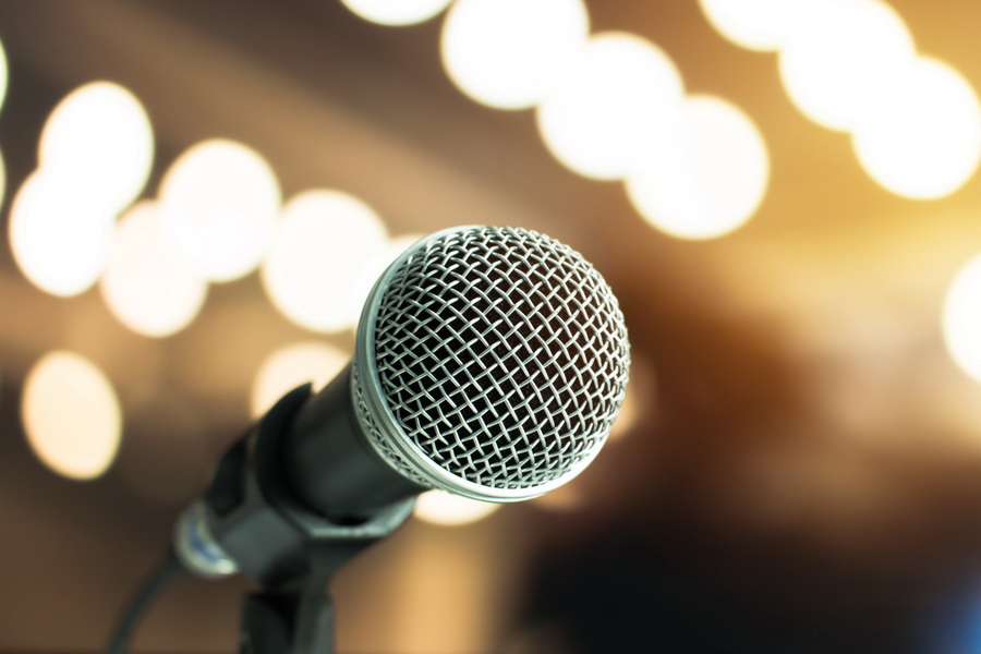 close up of microphone with blurred stage lights in the background